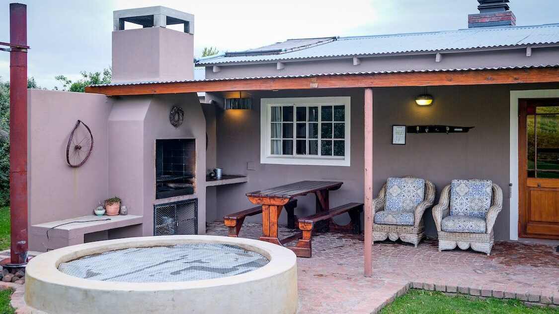 Outdoor hot tub set on a private patio with seating, barbecue area, and covered terrace space